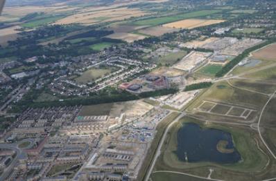 Aerial photograph of Trumpington from the south east, showing the Clay Farm park, lake, spine road, Abode, Paragon, Hobson Square and the Clay Farm Centre, Aura, Halo, the tree belt along the busway and the village centre from Shelford Road to Long Road. Countryside, 16 August 2016.